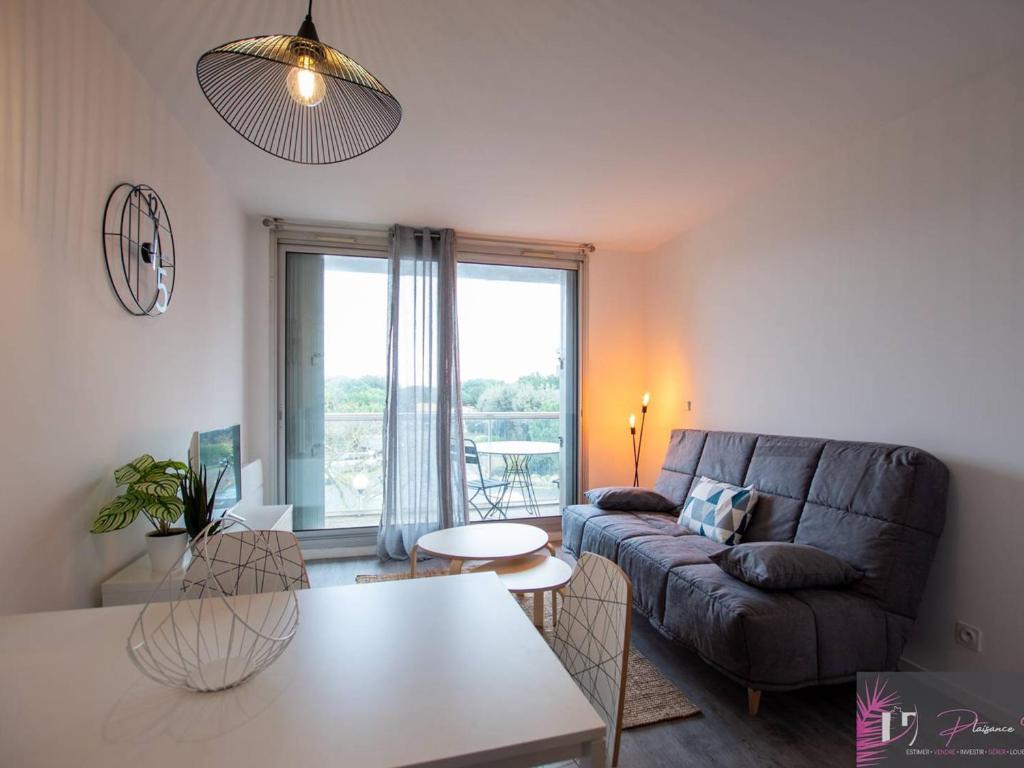 un salon avec un canapé et une table dans l'établissement Studio rénové à 50m de l'océan à La Rochelle - FR-1-825-41, à La Rochelle