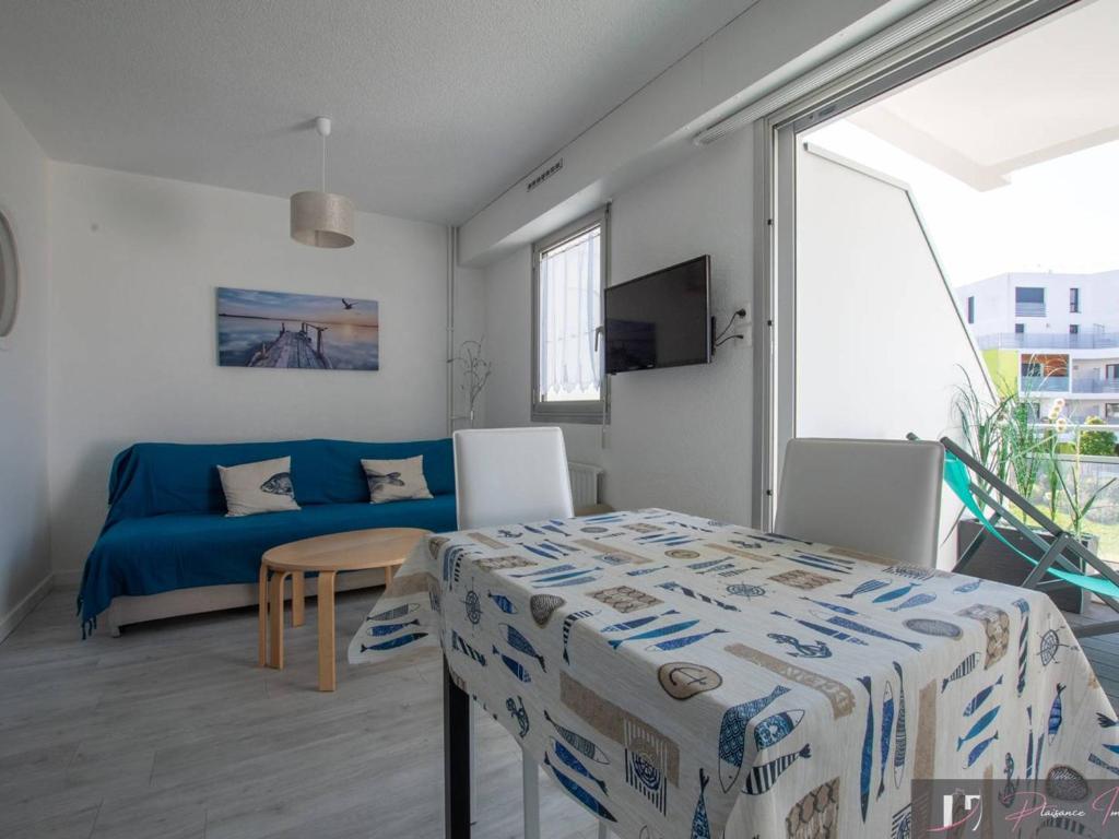 un salon avec un canapé bleu et une table dans l'établissement Studio bis avec balcon à La Rochelle, parking inclus - FR-1-825-16, à La Rochelle