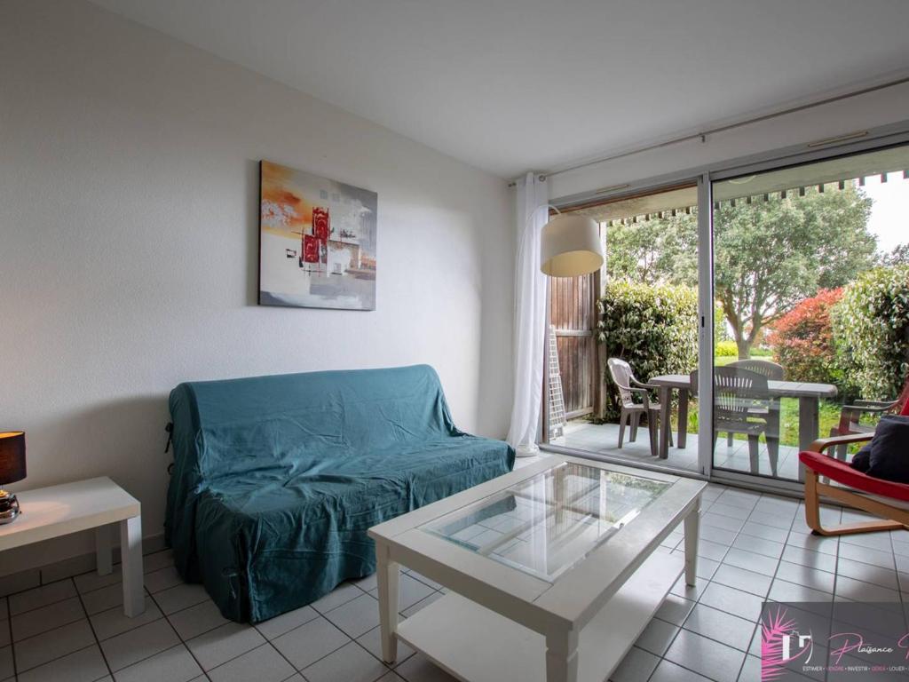 un salon avec un canapé et une table en verre dans l'établissement Studio meublé 4 pers, terrasse et parking proche mer - FR-1-825-23, à La Rochelle