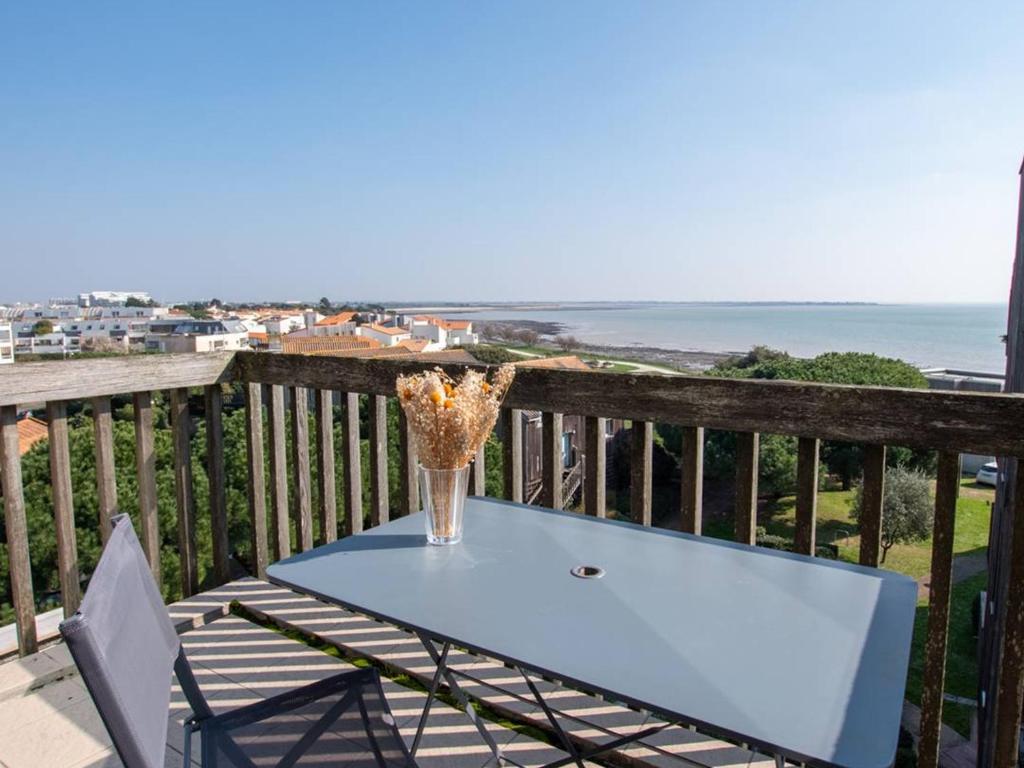 une table avec un vase au-dessus d'un balcon dans l'établissement Appartement T2 meublé, 4 couchages, vue sur mer avec Wifi - FR-1-825-42, à La Rochelle