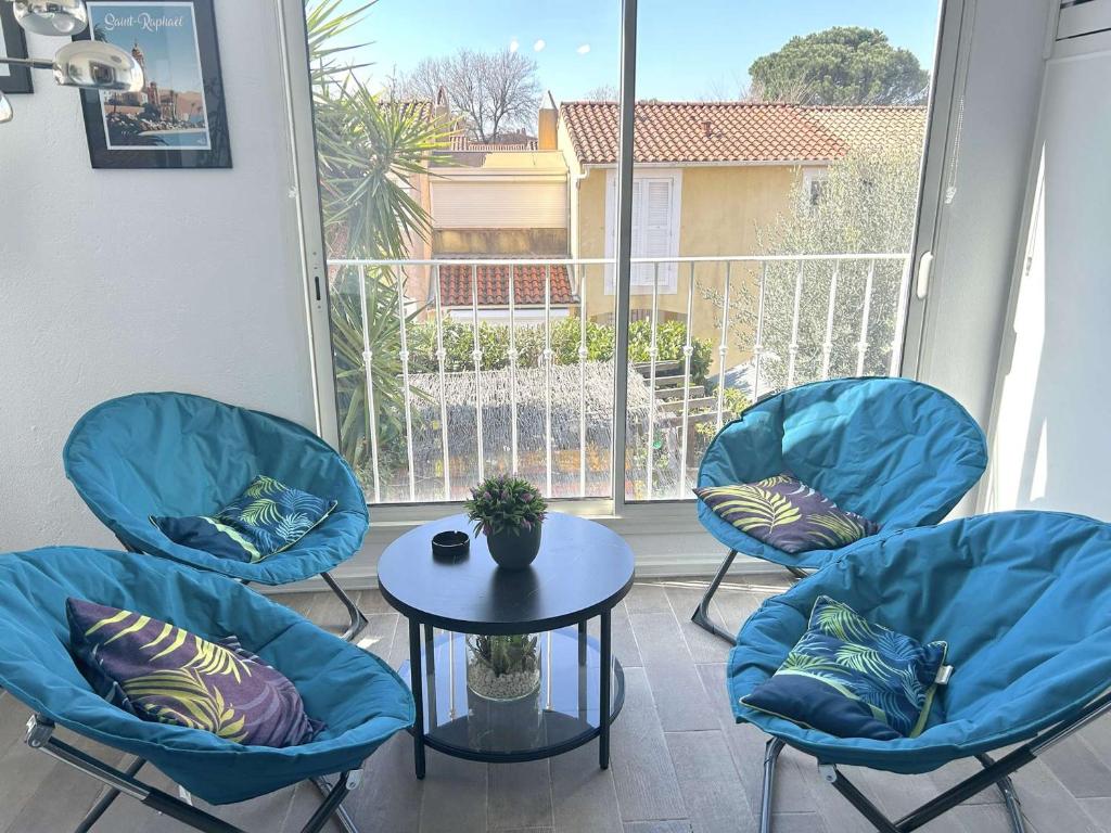 d'un balcon avec 3 chaises, une table et une fenêtre. dans l'établissement Appartement spacieux 3 pièces, climatisé avec parking à Saint-Raphaël - FR-1-226A-202, à Saint-Raphaël