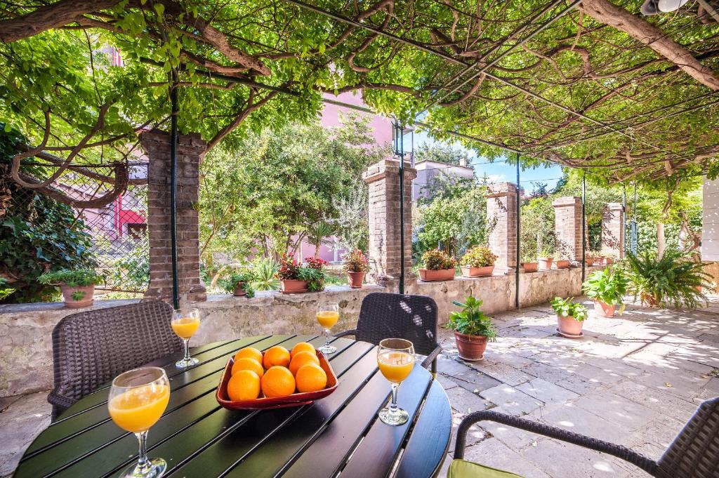 a wooden table with oranges and wine glasses on it at Apartment Heart of the City in Šibenik