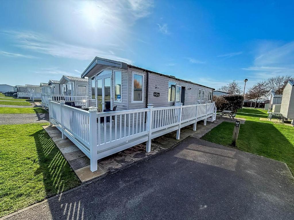 een stacaravan met een veranda en een huis bij Stunning Caravan With Decking At Haven Hopton-On-Sea Ref 80007L in Great Yarmouth