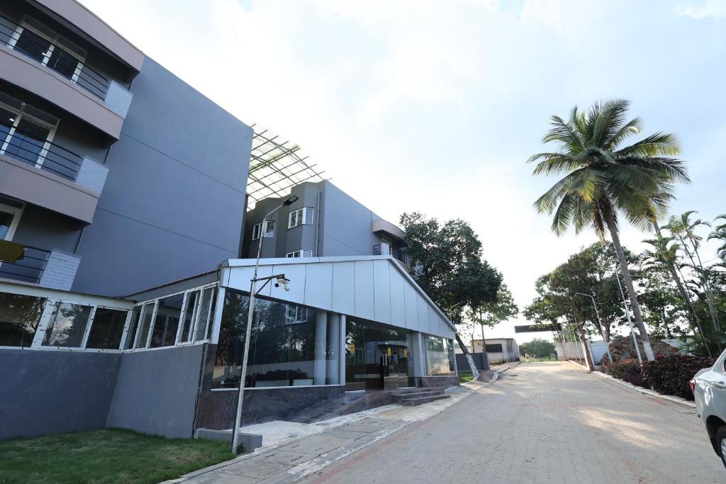 a building with a palm tree next to a street at Aaditya Greens Near Nelaguli Panchyat Office in Kaglipur