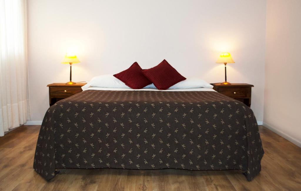 プエルト・マドリンにあるHotel Gran Madrynのベッドルーム1室(大型ベッド1台、ナイトスタンド2台付)