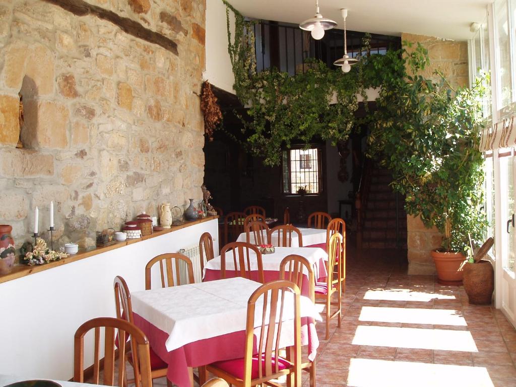 Un restaurante con mesas y sillas en una habitación. en Peñasalve, en Villamoñico