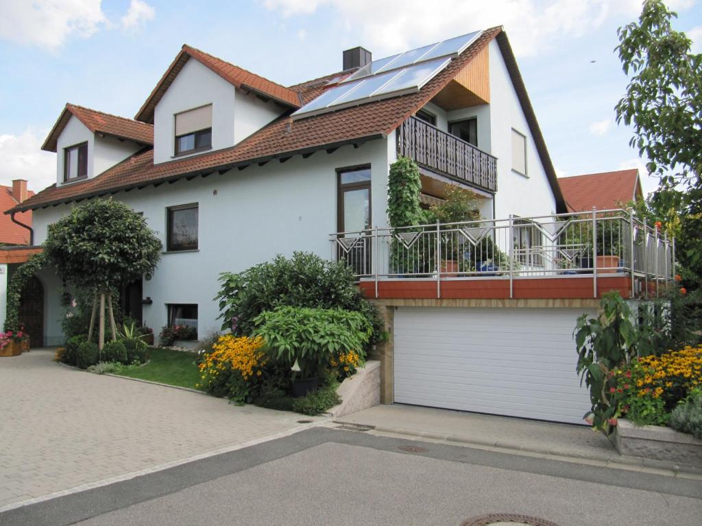 ein weißes Haus mit einem Sonnendach und einer Garage in der Unterkunft Abendstille am Obstgarten mit Terrasse in Zapfendorf