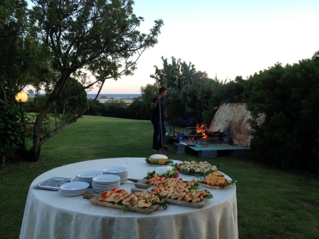 a table with plates of food on it with a fire at Hotel Spartivento in Chia