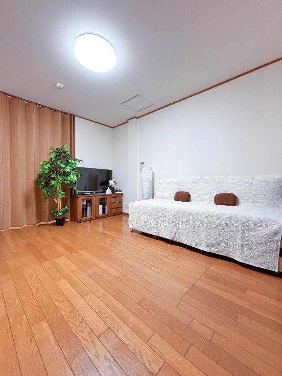 a bedroom with a bed and a flat screen tv at 桜の宿-大阪城Osaka castle-105m2 private-5Way access-KIX USJ 難波心斎橋 Direct in Osaka