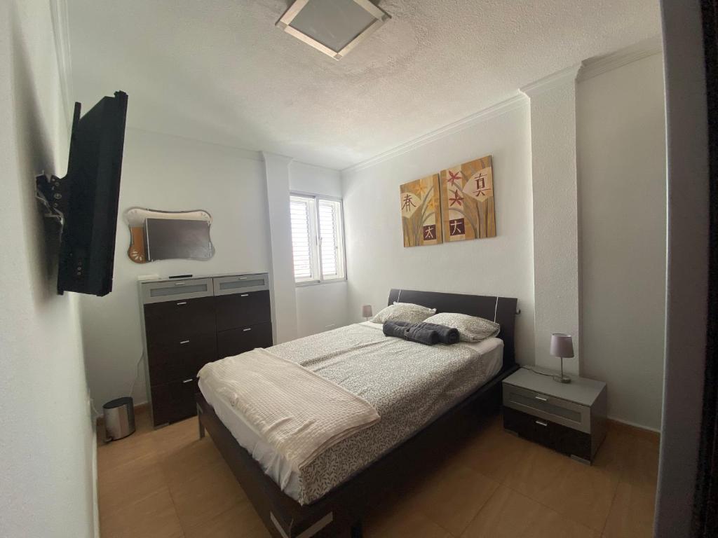 ein Schlafzimmer mit Bett und Flachbildfernseher in der Unterkunft EstrellaMar in Arinaga