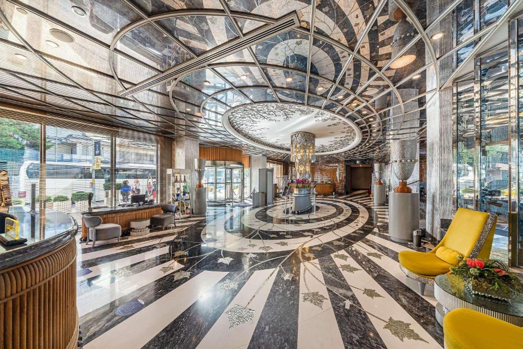 a lobby of a building with a large ceiling at Wyndham Grand Istanbul Kalamış Marina Hotel in Istanbul