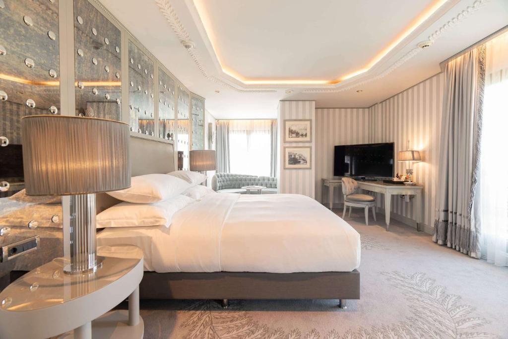 a bedroom with a large bed and a desk at Wyndham Grand Istanbul Kalamış Marina Hotel in Istanbul