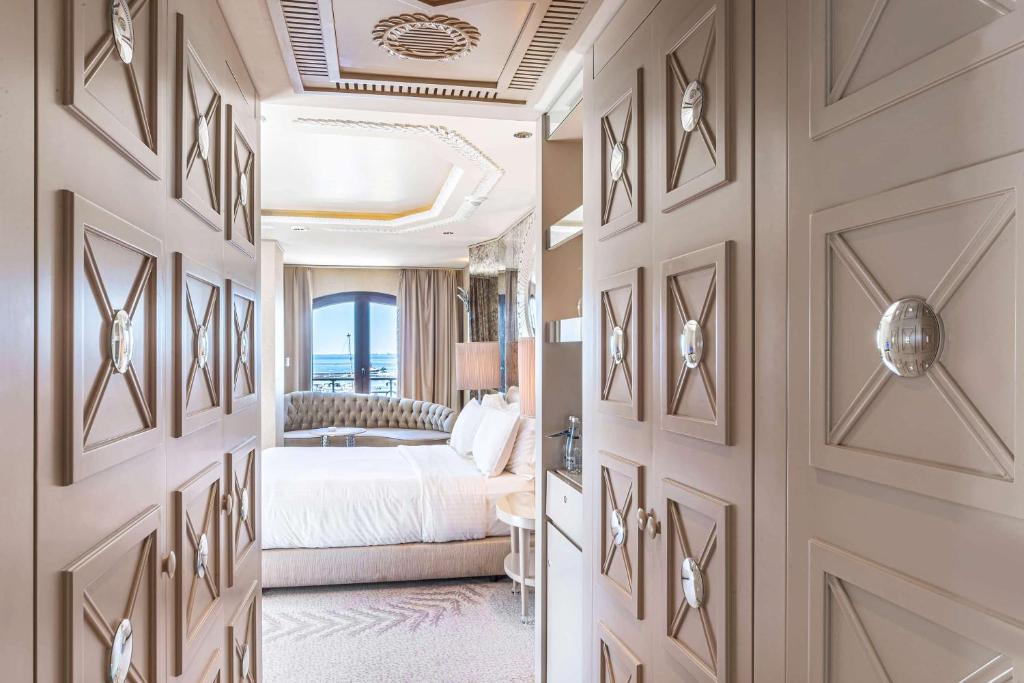 a hotel room with a bed and a hallway at Wyndham Grand Istanbul Kalamış Marina Hotel in Istanbul