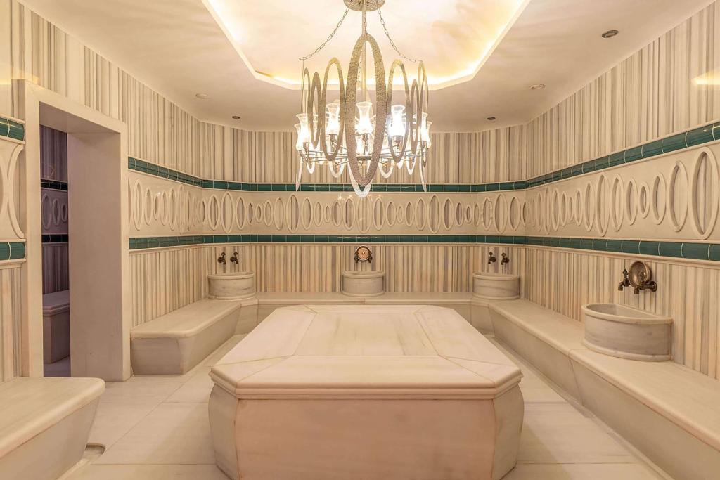 a large room with a chandelier and two sinks at Wyndham Grand Istanbul Kalamış Marina Hotel in Istanbul