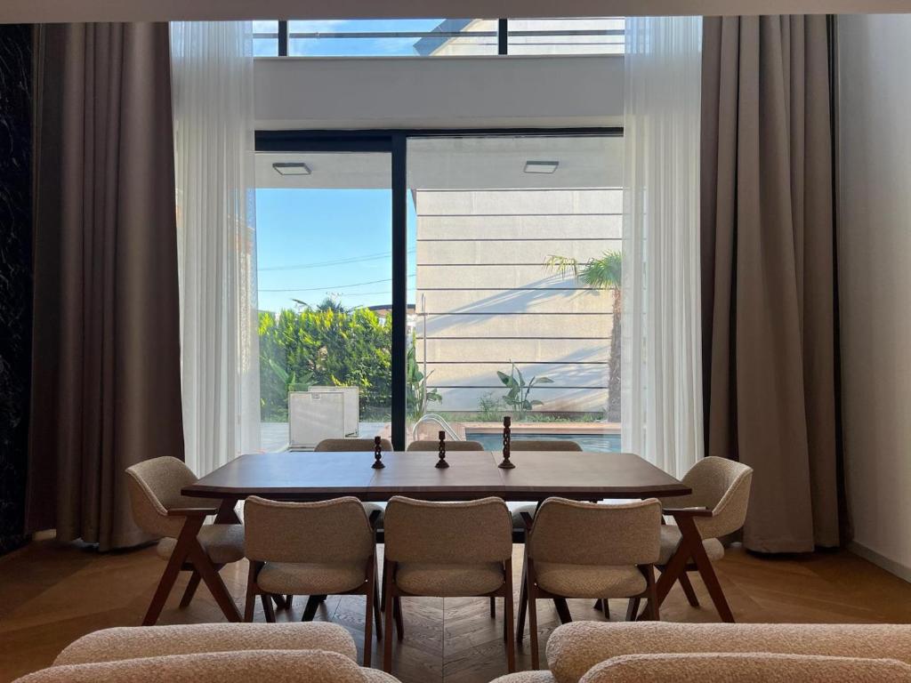 a dining room with a table and chairs and a large window at Royal Garden 7 Villas in Dosemealti