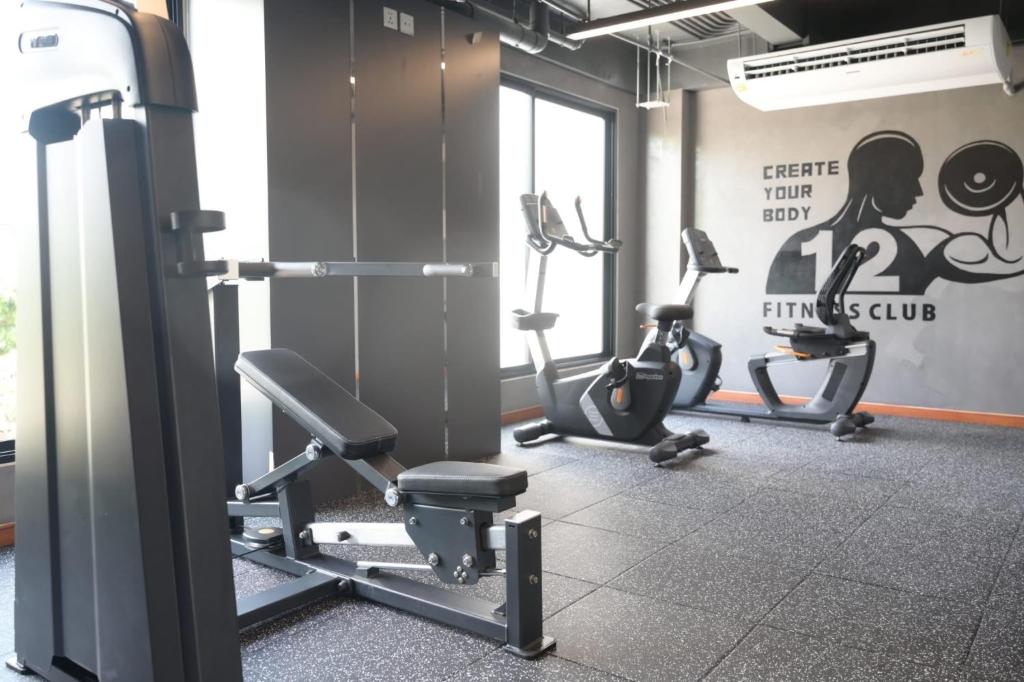 The gym combines cardio machines with a weight machine and adjustable bench.
