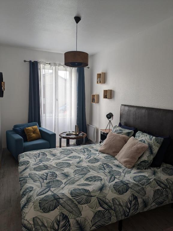 une chambre avec un lit et une chaise bleue dans l'établissement Les chambres du vieux quartier, à Thouars