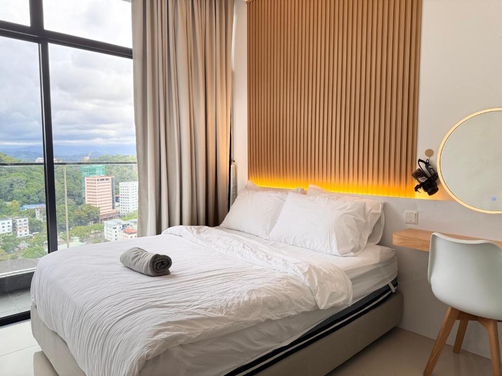 a bedroom with a bed with a mirror and a window at The Shore by New Voyage in Kota Kinabalu