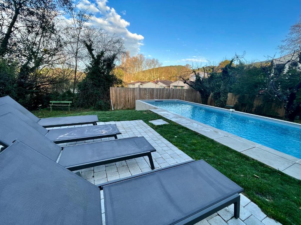 a backyard with a swimming pool with two tables and chairs at Maison & Jardin Coeur Luberon classé 4 étoiles in Peypin-dʼAigues