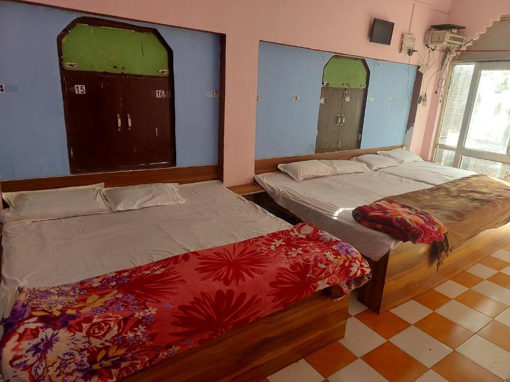 duas camas em um quarto com duas janelas em Annu Bhai Sewa Sadan em Matura
