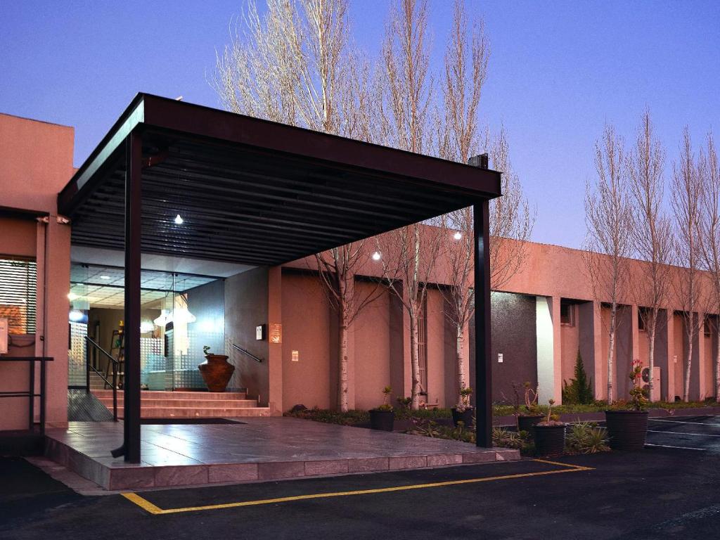 un edificio con una cubierta negra en un aparcamiento en Q's Evander Hotel & Apartments, en Evander