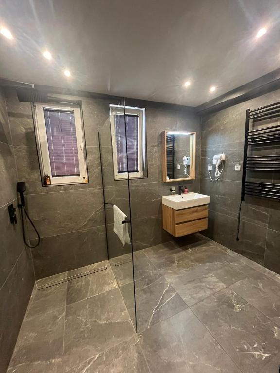 un bagno con doccia e lavandino di Garni Hotel TIANIS a Kotor (Cattaro)