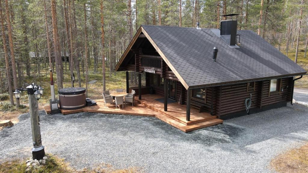a log cabin in the woods with a grill at Lakeside cabin Riekonkieppi in Kuusamo