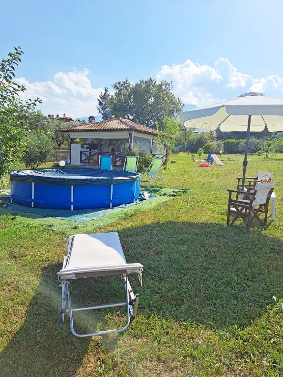 a picnic table and an umbrella and a pool at Casa Consta Olympus in Litochoro