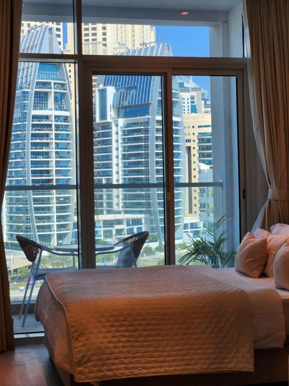 Schlafzimmer mit einem großen Fenster mit Stadtblick in der Unterkunft STUDIO ONE Stunning Marina View - TIE Hotels &amp; Resorts in Dubai
