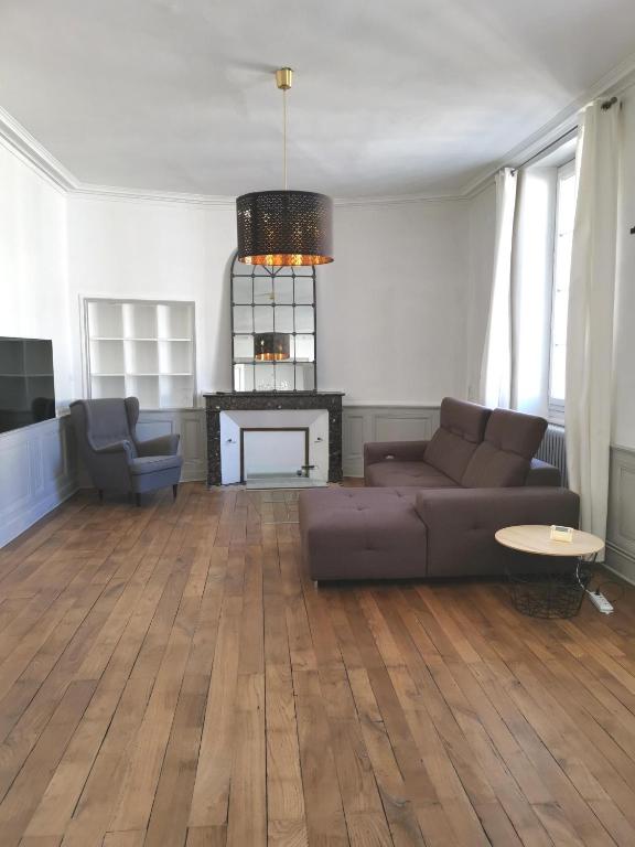 un salon avec un canapé et une cheminée dans l'établissement 117m2 - spacieux et lumineux, à Périgueux