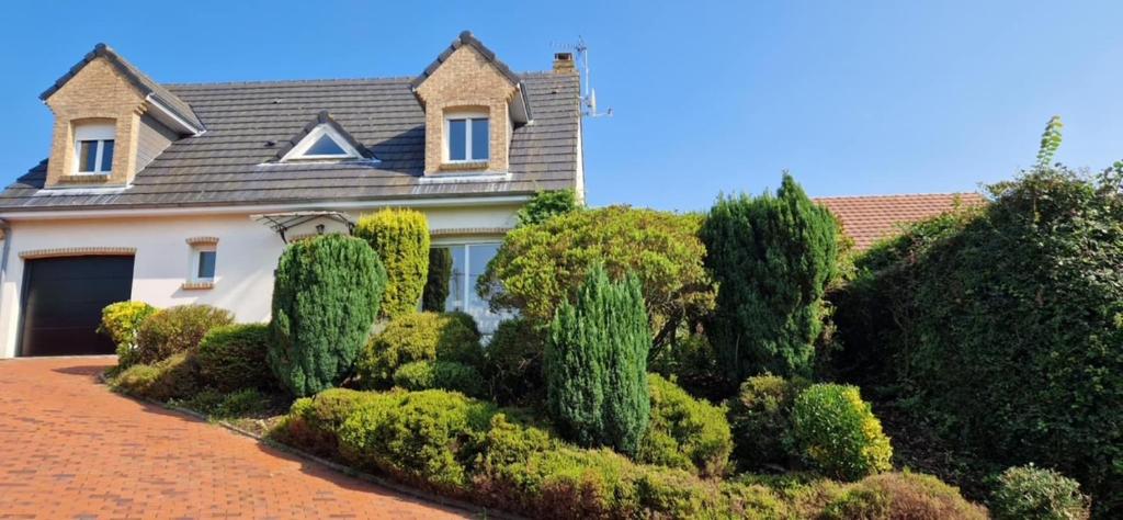 une maison avec une bande de buissons devant elle dans l'établissement Gîte les Bruyères, à Hesdin-lʼAbbé