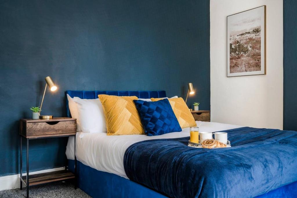 ein blaues Schlafzimmer mit einem Bett mit blauer Wand in der Unterkunft Sleeps 8 Ps5 Pool Table in Wellingborough