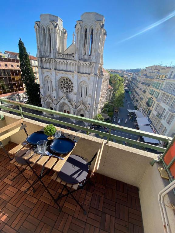 un balcon avec une table et des chaises sur un immeuble dans l'établissement Studio cosy en plein cœur de Nice, à Nice
