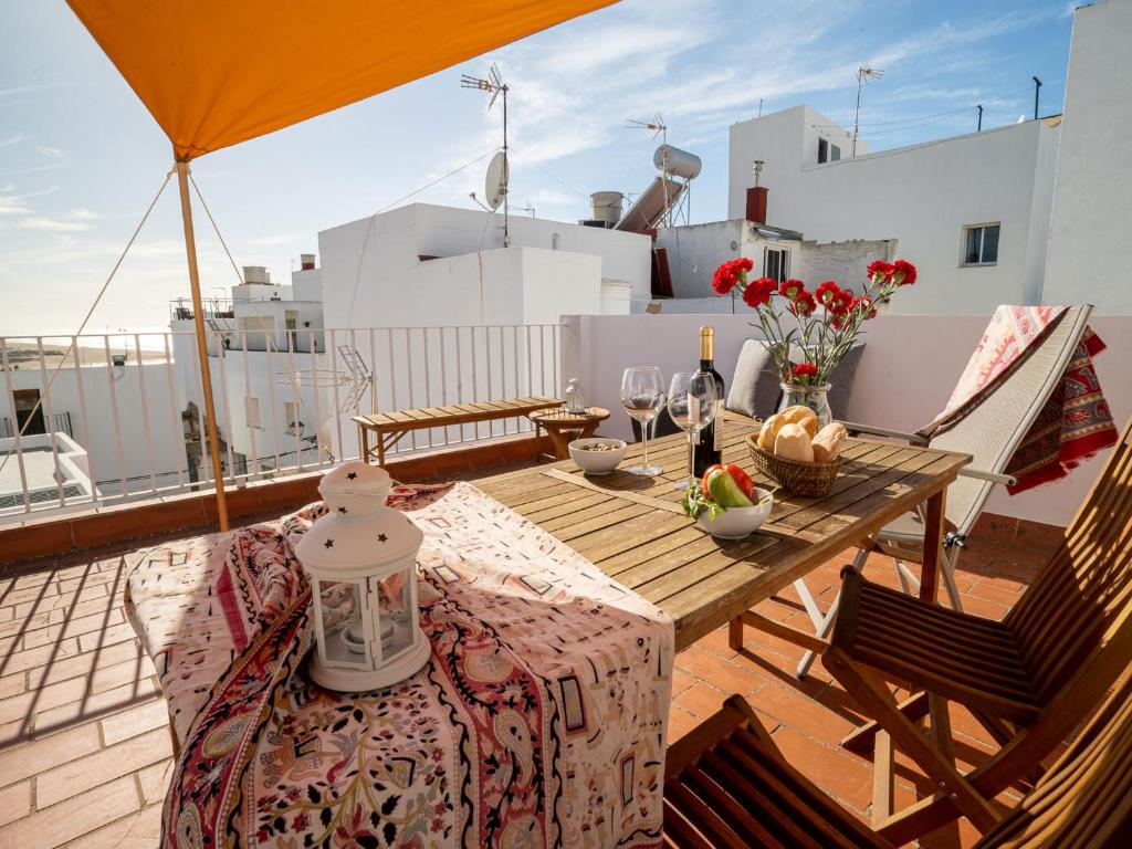 une table et des chaises sur le toit d'une maison dans l'établissement Casa Irene Conil town house in the center, roof terrace with great views, à Conil de la Frontera