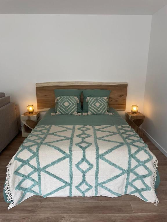 une chambre avec un lit avec une couette bleue et blanche dans l'établissement Studio Les Hauteurs de Juziers, à Juziers