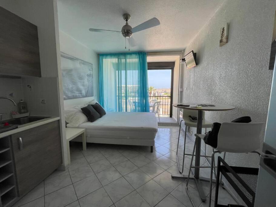 une chambre avec un lit et une cuisine avec une table dans l'établissement Studio village naturiste Turquoise, au Cap d'Agde