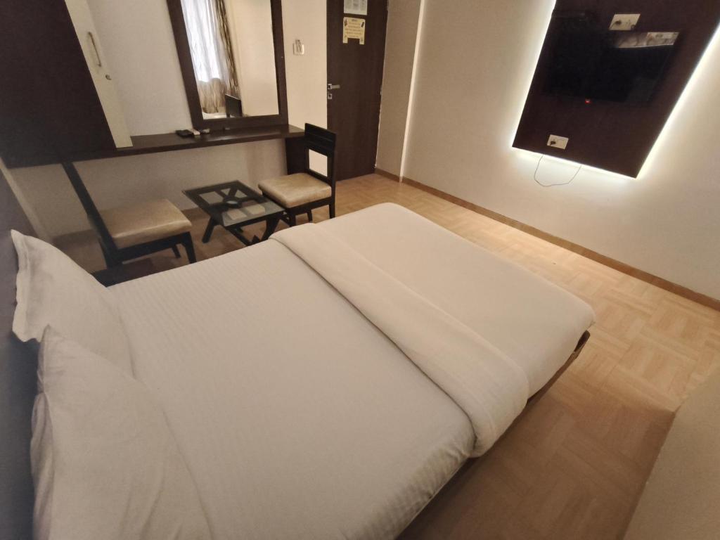 Säng eller sängar i ett rum på Hotel Vijay Sagar Dombivali