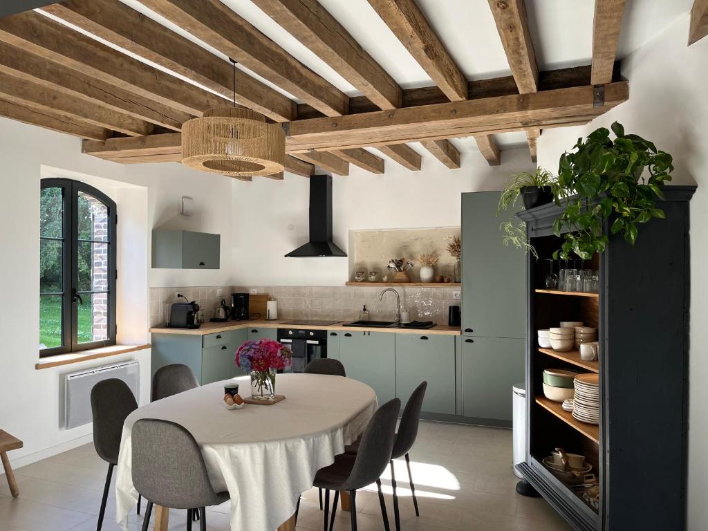 une cuisine avec une table et des chaises dans une pièce dans l'établissement Cottage au cœur du Perche, à Souancé-au-Perche