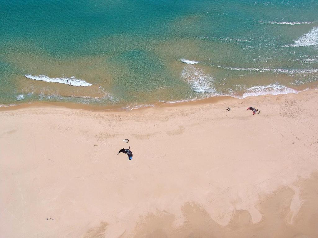a group of people on a beach near the ocean at Hotel Spartivento in Chia