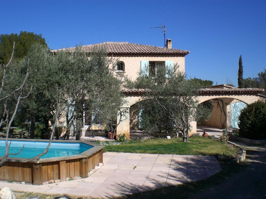 une maison avec une piscine en face d'une cour dans l'établissement Le clos des oliviers, à Ventabren