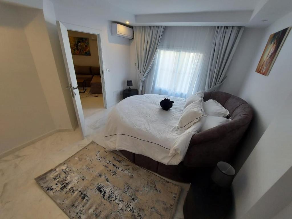 a black cat sitting on a bed in a bedroom at Luxury marsa beach in La Marsa