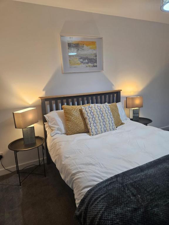 a bedroom with a bed with two tables and two lamps at No 14 Langley Work and Stay 3BR House Ideal for Contractors in Wick
