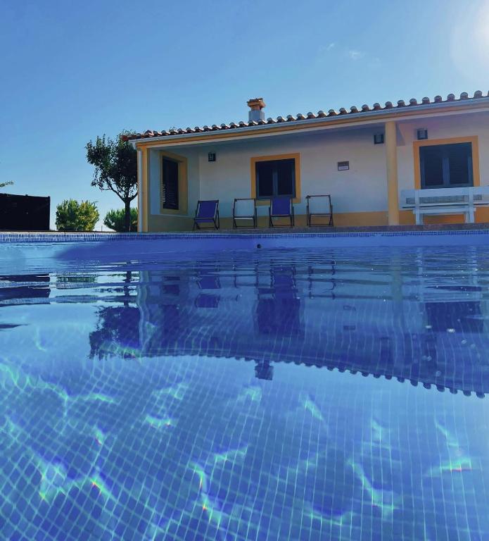 a villa with a swimming pool in front of a house at Monte Açores in Ferreira do Alentejo