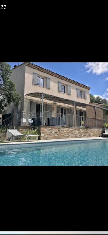 une grande maison avec une piscine devant dans l'établissement Bastide provençale 6-8 personnes, à Pourrières