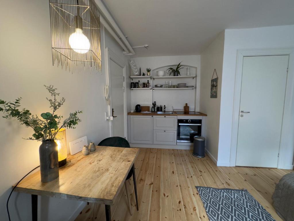 a living room with a wooden table and a kitchen at Kattesundet Apartments Best Location in Copenhagen in Copenhagen