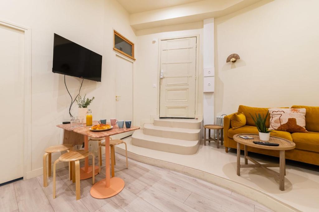 un salon avec un canapé et une table dans l'établissement Charmant appartement moderne haut marais - 4P, à Paris
