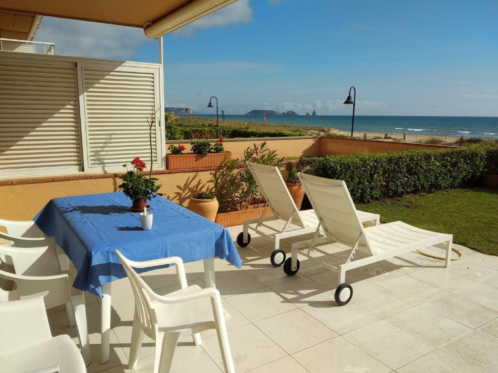 a table and chairs on a patio with the ocean at Golf Mar II C B-3 in Pals