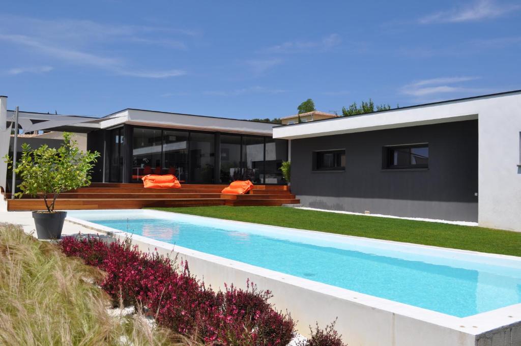une maison avec une piscine devant dans l'établissement L'Ecrin Contemporain, à Nages-et-Solorgues
