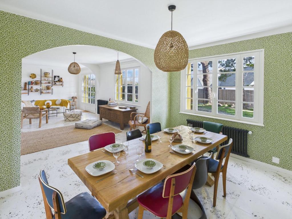 a dining room with a table and chairs at Maison pour 8 - Piscine chauffée - 800m de la plage in Penmarcʼh