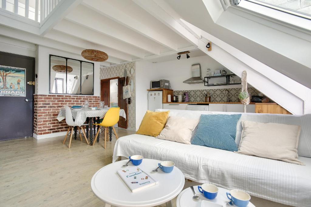 un salon avec un canapé blanc et une table dans l'établissement Appartement pour 4 à 200m de la plage du Prieuré, à Dinard